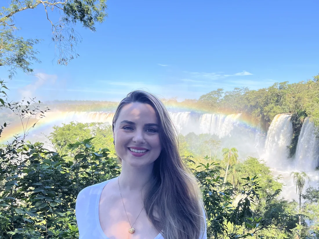 Elaine Cristina Zuchi nas Cataratas do Iguaçu, com um arco-íris sobre as quedas